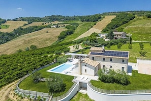 A villa with a swimming pool, surrounded by lush greenery and hilly terrain. - Luxury villa with pool in Aso Valley (Monterubbiano)