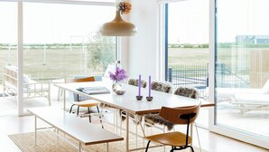 A modern dining area with a wooden ceiling, large windows, and a view of the outdoors. - Newly built summer house with sea view (Haderslev)