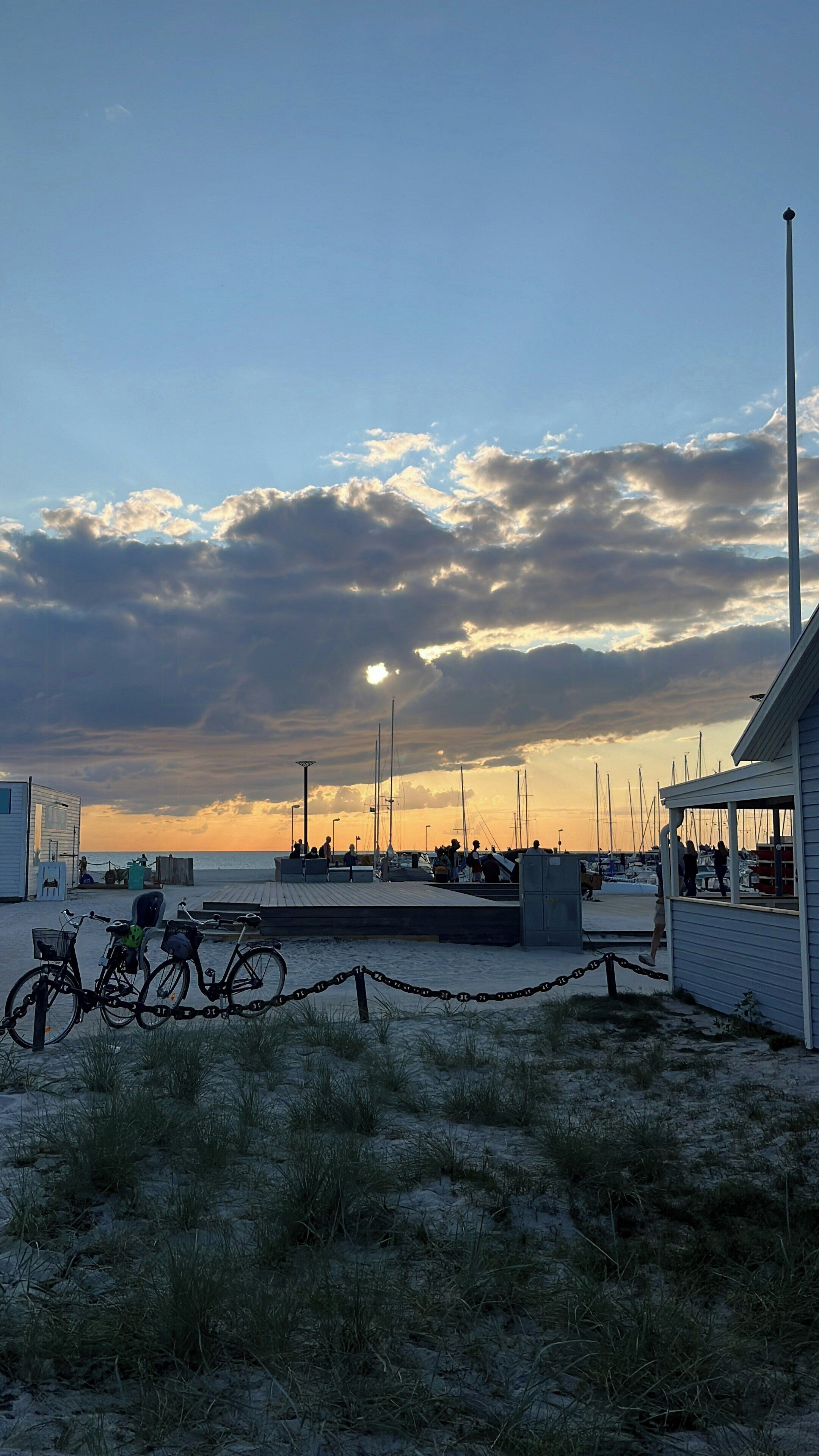 A marina with boats, a bicycle, and a building with a balcony.