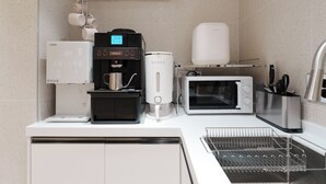 Una cocina moderna con cafetera, microondas, tostadora y dispensador de agua.
