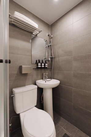 Une salle de bain moderne équipée de toilettes, d’un lavabo et d’une douche.