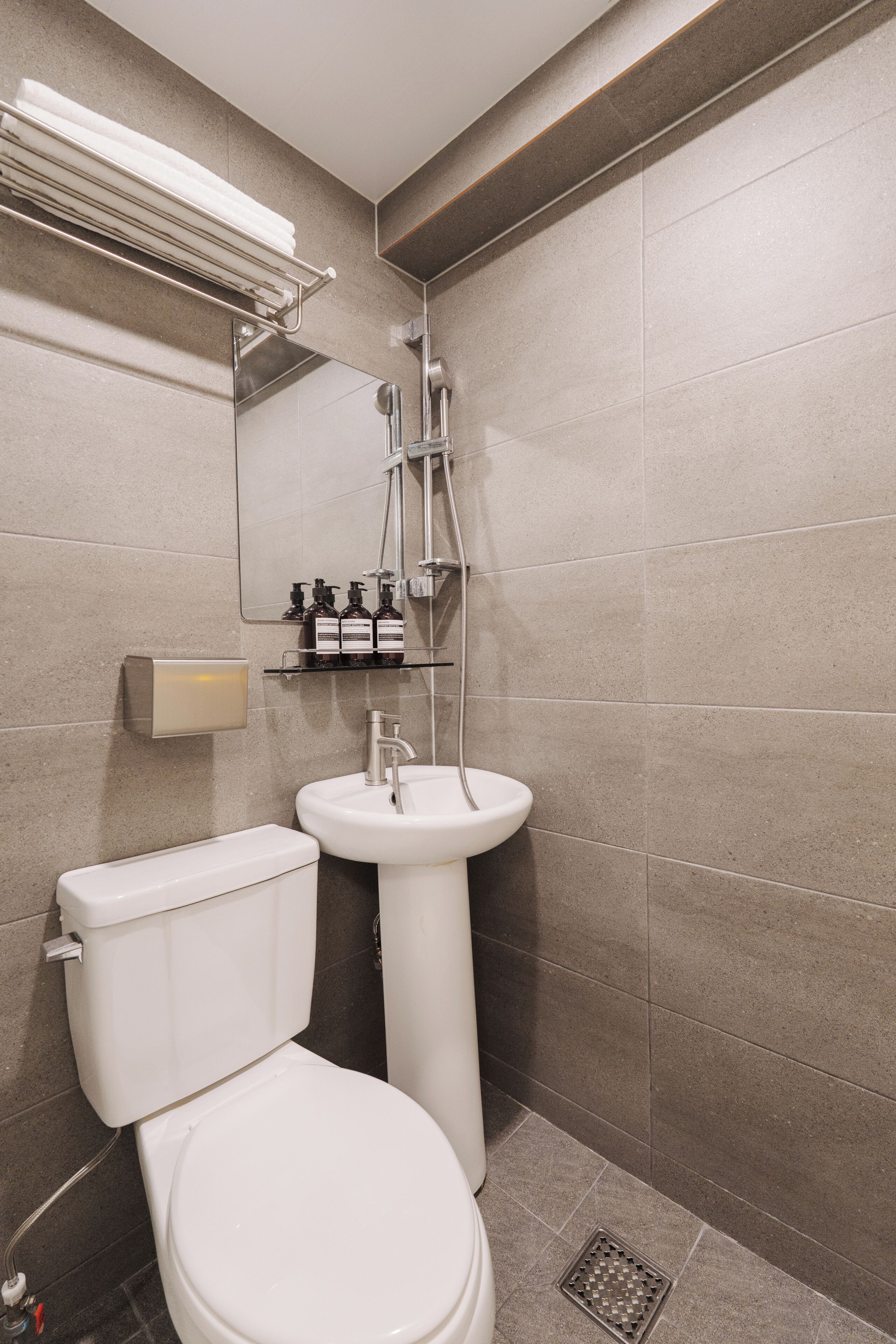 A modern bathroom with a toilet, sink, and shower.