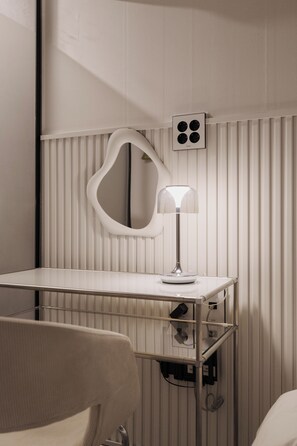 A modern bathroom with a vanity, mirror, and lamp.