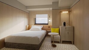 A hotel room with a bed, bedside table, and a small round table with a chair. - S-peria Hotel SAPPORO (Sapporo)