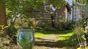 A garden pathway leading to a wooden fence. - Artist studio by Helge River in Skåne (Broby)