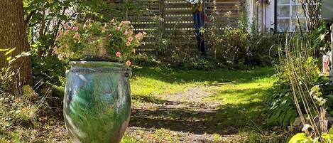 A garden pathway leading to a wooden fence.