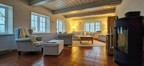 Ein Wohnzimmer mit Kamin, Sofas, einem Couchtisch und einem Fernseher.