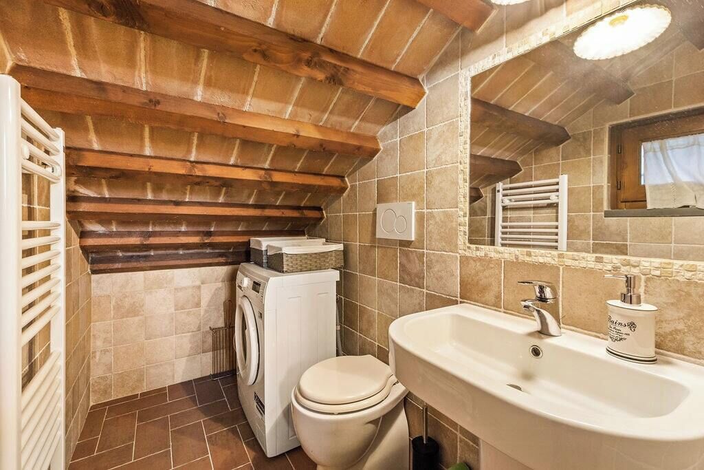 Un baño pequeño con lavadora, inodoro y lavamanos.