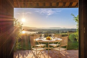 An outdoor dining area with a table set for two, overlooking a scenic landscape. - House with lakeview between Tuscany and Umbria (Castiglione del Lago)