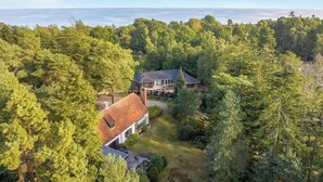 Una casa rodeada de un bosque frondoso con vista al océano.