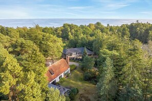 Ein Haus, umgeben von dichtem Wald, mit Blick auf den Ozean.