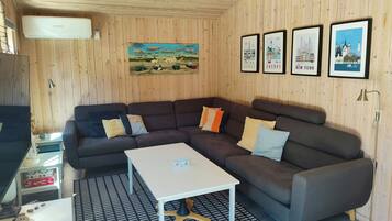 Et hyggeligt rum med en hjørnesofa, et lille bord og en gulvtæppe med et mønster.