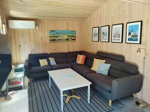 Ein gemütliches Zimmer mit einer Eckcouch, einem kleinen Tisch und einem gemusterten Teppich.
