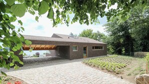 Een modern huis met een bakstenen gevel, een verharde oprit en een tuin.