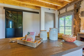 A rustic interior with a wooden table displaying jars, a basket, and a sign. - Traditional house in the Gascogne forest (Trensacq)