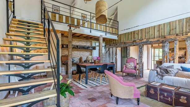 A spacious loft with a wooden staircase, a dining area, and a cozy seating area. - Traditional house in the Gascogne forest (Trensacq)