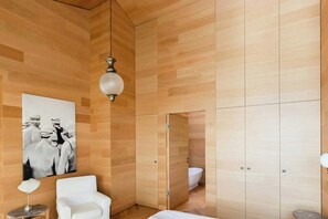 Ein modernes Badezimmer mit Holzverkleidung, einer weißen Badewanne und einem großen Schwarz-Weiß-Foto an der Wand.