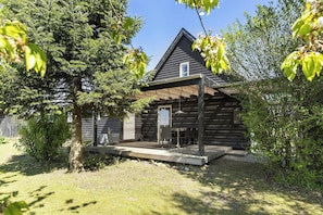 A wooden cabin with a covered porch, a small window, and a grassy yard. - Architectural house with views of Bornholm nature (Åkirkeby)