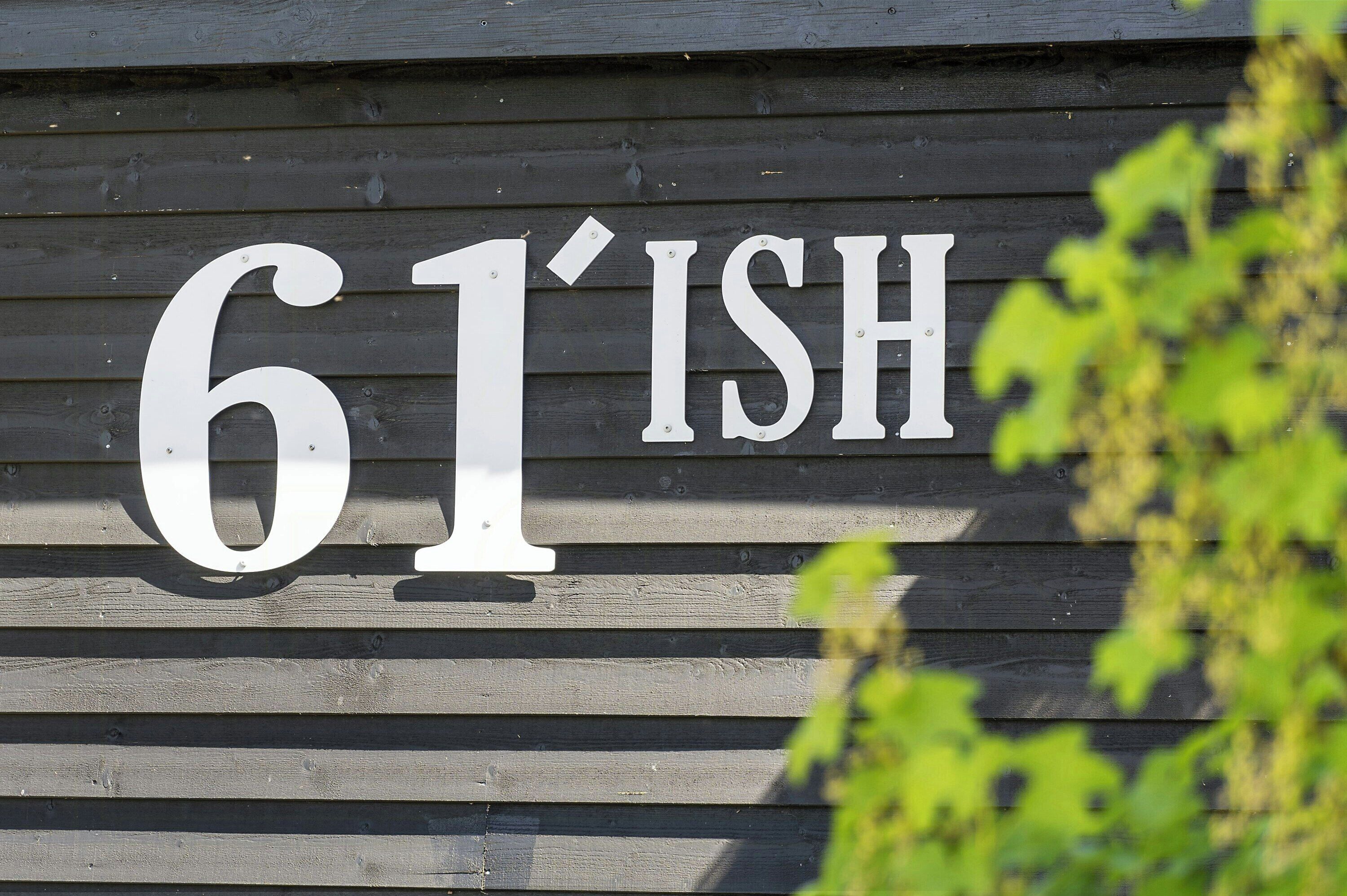 Pared de madera con el número '61' y las letras 'ISH'.