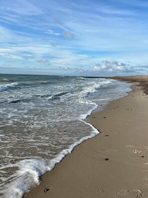 A beach with waves, a clear sky, and footprints in the sand. - Historic house near Råbjerg Mile and North Sea (Skagen)