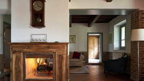 Un salon chaleureux avec une cheminée, une horloge et un canapé.