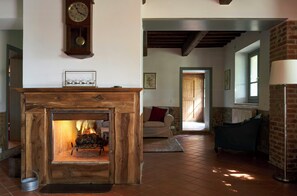 Un accogliente soggiorno con camino, un orologio e un divano.