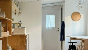 Een keuken met houten planken, een wit aanrecht en een houten vloer.