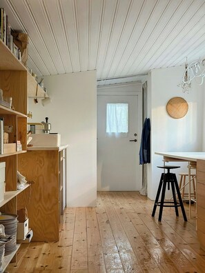 Eine Küche mit Holzböden, einer weißen Arbeitsplatte und Regalen aus Holz.