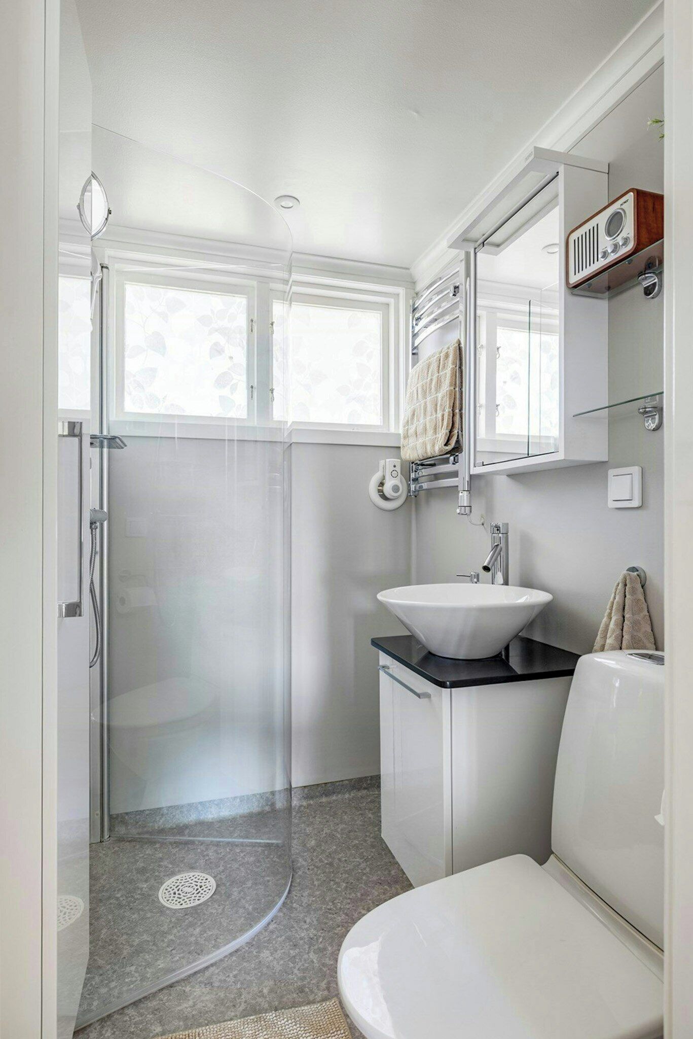 Une salle de bain moderne avec une douche à parois de verre, un lavabo blanc et des toilettes.