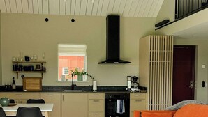 A modern kitchen with a dining area, a sofa, and a coffee table.