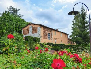 A building with a stone facade, a visible window, and a street lamp. - Quiet Getaway in the Heart of Tuscany (Segromigno in Monte)