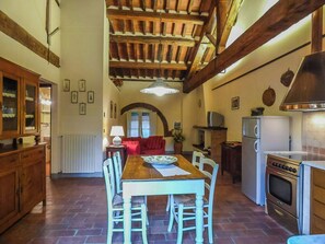 A kitchen with a dining table, chairs, a stove, and a refrigerator. - Quiet Getaway in the Heart of Tuscany (Segromigno in Monte)