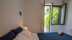 Een slaapkamer met een bed, een raam en een deur.