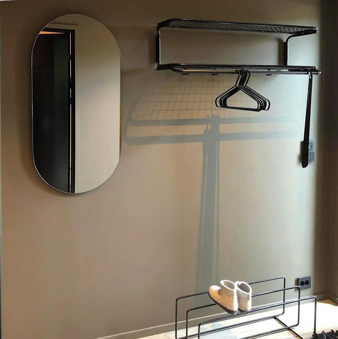 Une salle de bain équipée d’un miroir, d’un porte-serviettes, d’une étagère et d’un porte-chaussures.