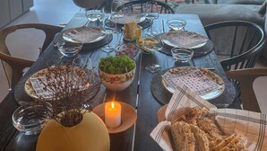 Una mesa puesta para una comida, con una vela, cuencos y pan.