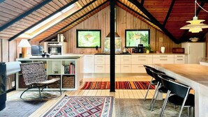 A loft-style kitchen with a high ceiling, wooden beams, and a large window. - Traditional Kalmar house close to the beach (sjaellands odde)