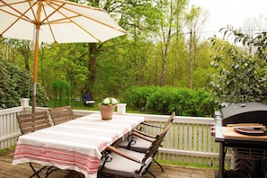 An outdoor deck with a table and chairs, a grill, and a potted plant. - The Hallandsåsen lighthouse, a natural retreat (Munka-ljungby)