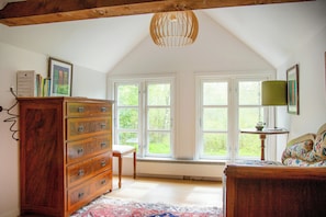 A room with a wooden dresser, a chair, a bed, and large windows allowing natural light. - The Hallandsåsen lighthouse, a natural retreat (Munka-ljungby)