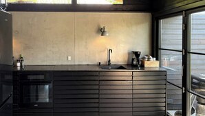 Een moderne keuken met een inbouwoven, een spoelbak en een raam met uitzicht op buiten.