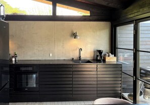 Eine moderne Küche mit Backofen, Spüle und Fenster mit Blick nach außen.
