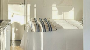 Ein Schlafzimmer mit Bett, Tür, einer runden Wanddekoration und Holzboden.