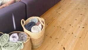 Uma sala de estar acolhedora com sofá, poltronas, mesa de centro de madeira, lareira e televisão.
