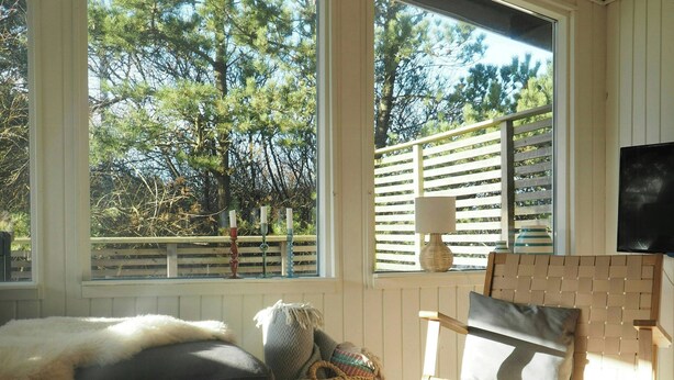 A room with a large window, a round table, a sofa, and a television. - Traditional holiday home at Cold Hawaii (Thisted)
