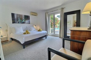 A hotel room with a bed, a desk, a chair, a mirror, and a view of the outdoors. - Villa with heated pool near the Alpilles (Saint Rémy de Provence)