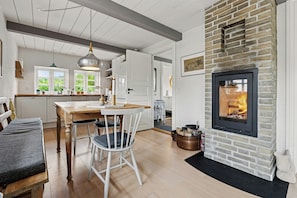Ein gemütliches Interieur mit Kamin, Holzmöbeln und Blick ins Grüne.