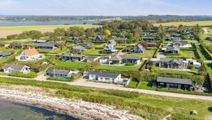 Een woonwijk met huizen, een strand en een waterpartij.