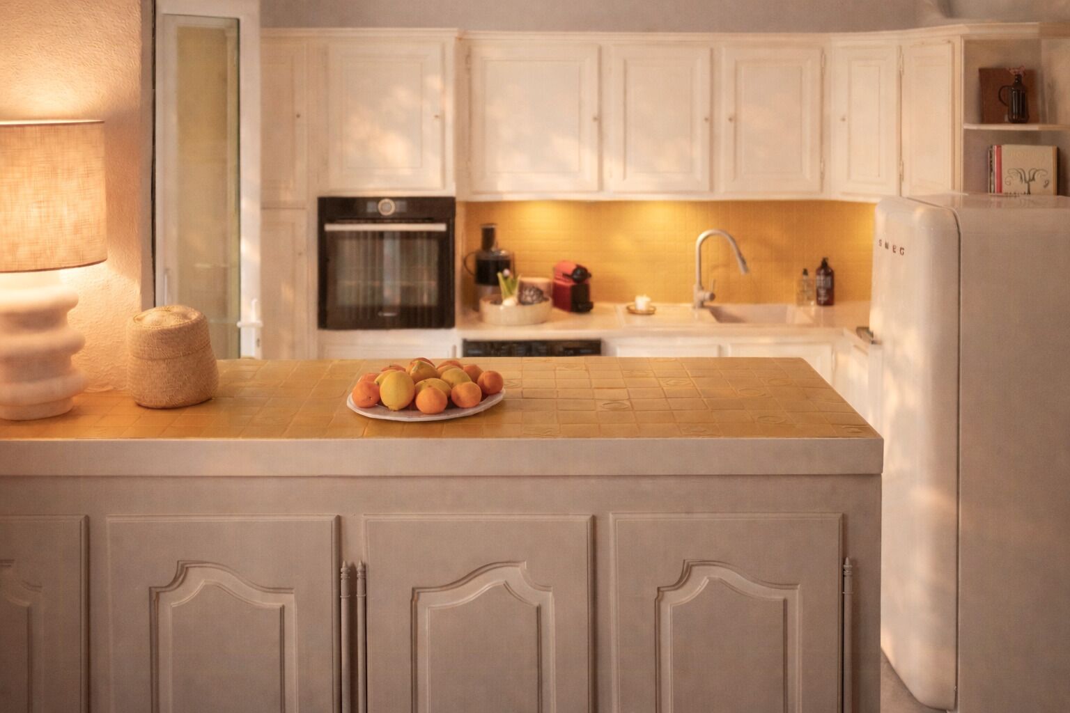 A kitchen with white cabinets, a wooden countertop, a sink, a stove, and a refrigerator.