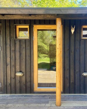 Eine Holzhütte mit einer großen Tür, einem kleinen Fenster und einer Schädeldekoration.