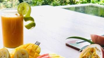 A table with a fruit platter and a glass of orange juice.