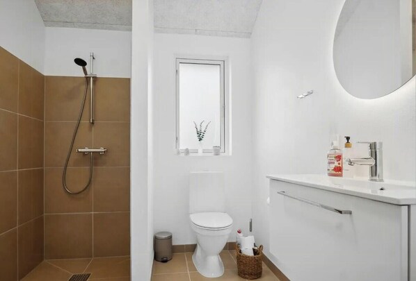 A bathroom with a shower, toilet, and sink.